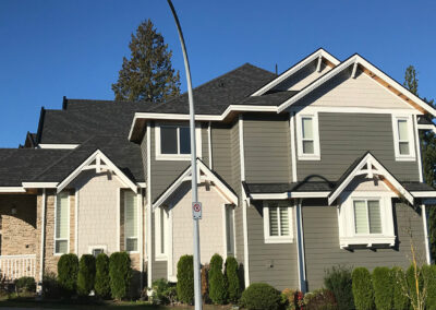 Grey craftsman-style home with white trim and many windows
