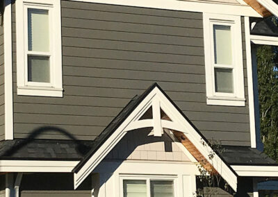 Grey home gable with white trim and windows