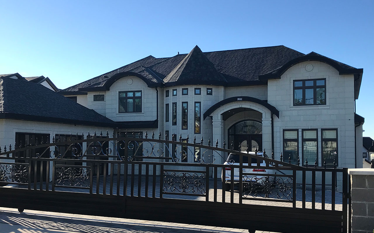 Large house with a dark fence and multiple gables