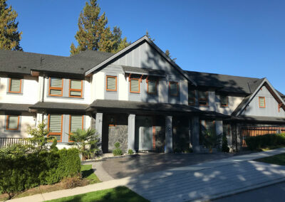 Row of homes with grey siding and orange-framed windows