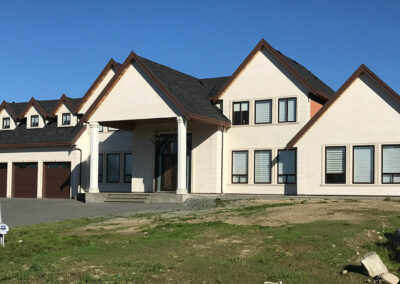 Cream home with gables, a covered porch and new windows