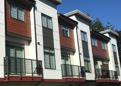 Modern townhomes with red and white panels and glass balconies