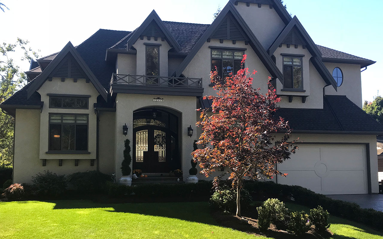 Large two-storey home with gabled roofs and an arched front entrance