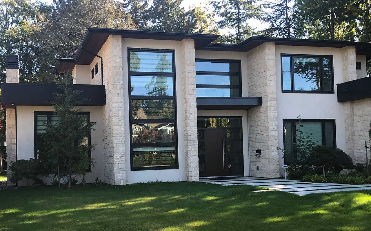 Two-storey modern home with black-framed windows and stone cladding