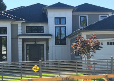Modern two-storey home with dark windows and a horizontal slat fence