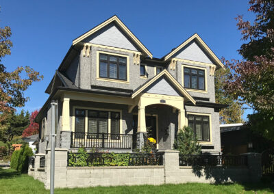 Craftsman-style home with a yellow entrance, covered porch and black-framed windows