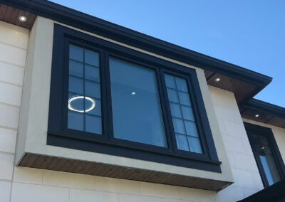Black-framed window with grid bars on a cream home exterior