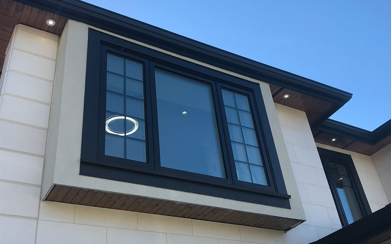 Dark-framed casement window on the upper storey of a cream home