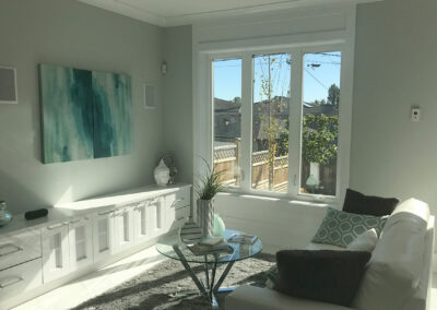 Bright living room with a white built-in cabinet, sofa and large windows