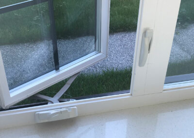 Open casement window looking onto grass and gravel