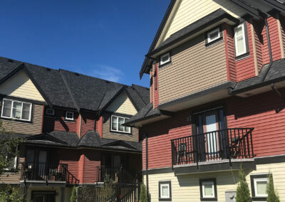 Red and brown townhomes with balconies seen from the corner
