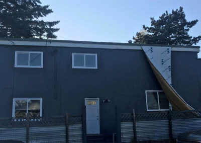 Dark grey home exterior with new windows and a side door