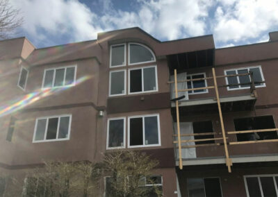 Three-storey brown apartment building with arched and rectangular windows